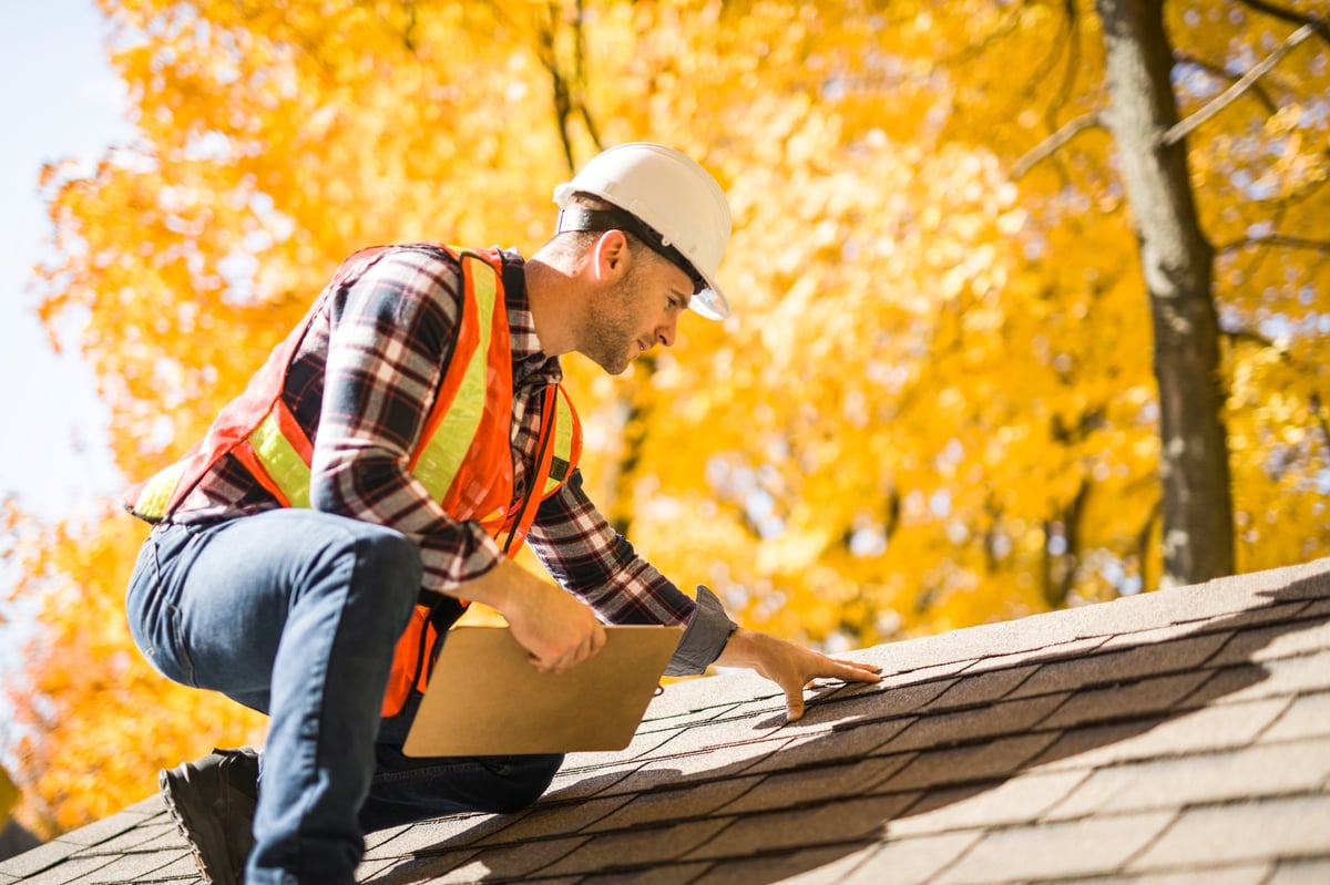 Professional contractor inspecting roof